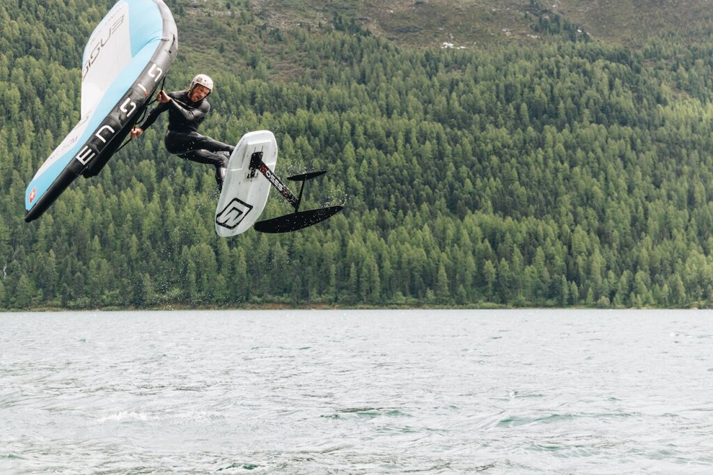 Der Silvaplana Ambassador Balz Müller zeigt beim Wingfoilen einen Freestyle Trick und springt in die Luft.